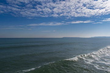 Snowy beach and sea at winter with blue sky
