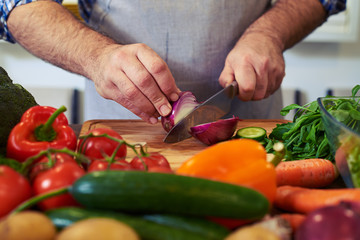 Crop shot of hands cutting an onion with a knife