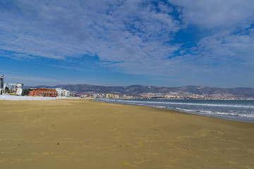 Snowy beach and sea at winter with blue sky