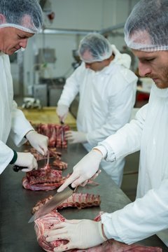 Butchers cutting meat 
