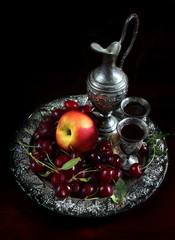 Peach and cherries on a metalic plate