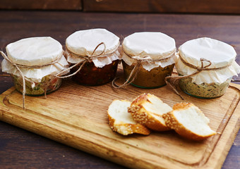 Opened jars with ready-to-it food standing on the wooden board