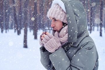 Outdoor shot of woman drinking tea or coffee from the cup