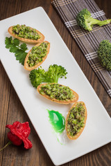 Tartlets stuffed with minced meat  broccoli and tuna. Wooden background