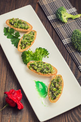 Tartlets stuffed with minced meat  broccoli and tuna. Wooden background
