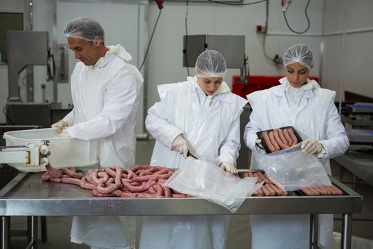Butchers packing sausages