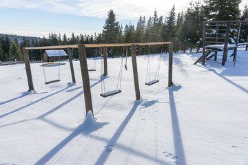 Empty swing with snow in winter season