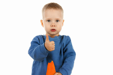 Happy baby boy eating carrot, isolated