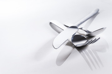 Messer, Gabel und Teelöffel auf spiegelndem Untergrund, Hintergrund