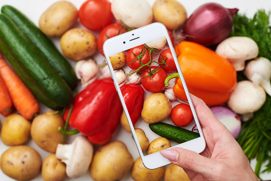 Top view of phone takes picture of fresh vegetables