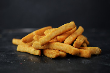 Fresh fried french fries with ketchup on black background.