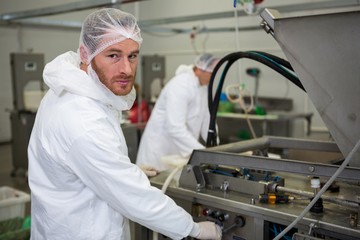 Butcher operating machine at meat factory