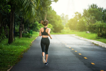 Young fitness sport woman running on the road in the morning.