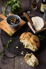 pane spezzato, formaggio e olive su vassoio di ferro