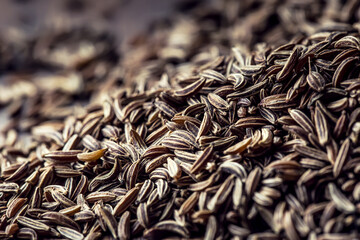 Cumin.Caraway seeds on wooden table. Cumin in vintage bronze bowl and spoon.