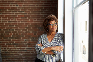 Fototapeta premium Mature Businesswoman Standing By Office Window