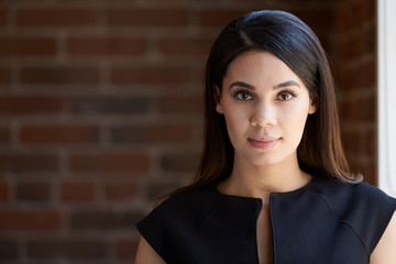 Head And Shoulders Portrait Of Young Businesswoman In Office
