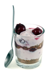 Crumble aux cerise avec une petit cuillère sur fond blanc 