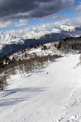 Fototapeta na wymiar Skiers on ski slope at sun winter day