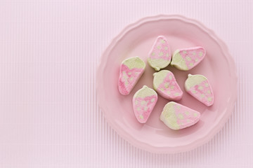 Erdbeerförmige Marshmallows auf einem rosa Teller