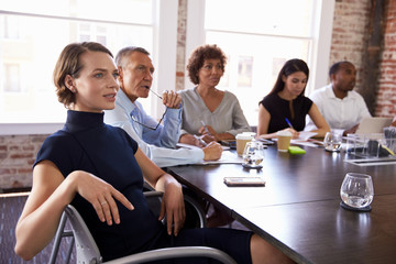 Businesspeople Listening To Presentation In Boardroom