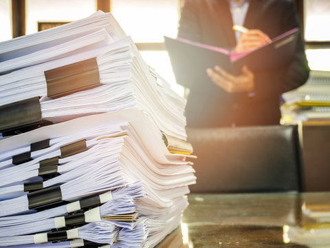 Close up of business documents stack on businessman background