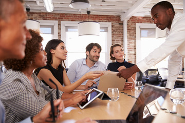 Businesspeople Meeting Around Table In Modern Office