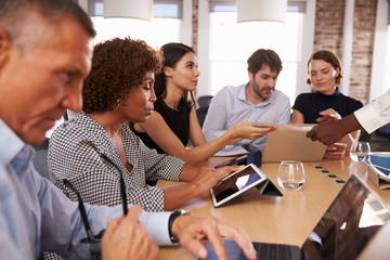 Businesspeople Meeting Around Table In Modern Office