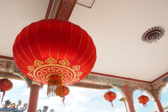 A red lattern with the gold line at the ceiling of the chinese temple church.
