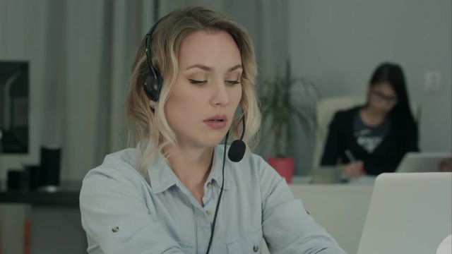 Call operator filling in client data on her laptop in the office