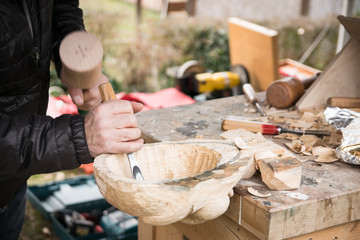 Old Carpenter carving a wooden carnival mask.