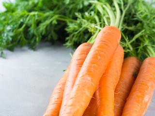 Fresh carrots on gray background. Healthy eating diet concept. Vegetables frame on table. Raw organic food