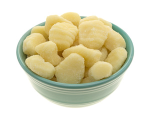 Plain potato gnocchi in a green bowl isolated on a white background.