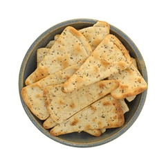 Seasoned pizza crust chips in an old bowl top view isolated on a white background.
