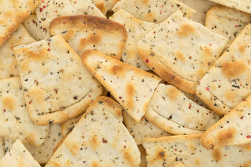 Close view of broken seasoned pizza crust chips.
