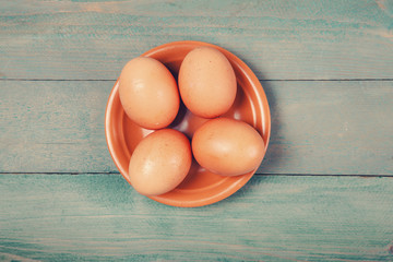 Raw, fresh chicken eggs on wooden background