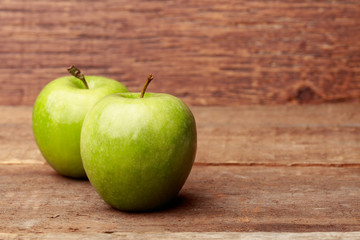 Two Fresh green apples on a wooden background 