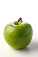 A side view of a green apple against a white background