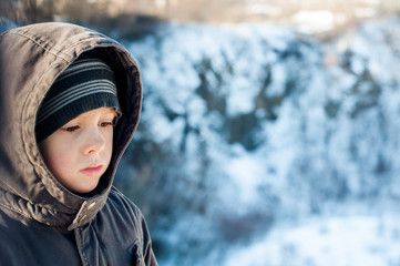 Portrait of sad lonely boy in winter