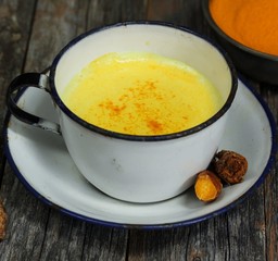 Turmeric Drink /  Golden Milk  on dark moody background, selective focus