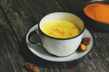 Turmeric Drink /  Golden Milk  on dark moody background, selective focus