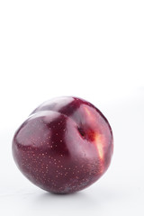 Obraz premium Single isolated purple spotted plum on a white background