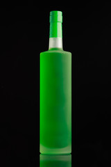 Bright green alcohol bottle on black background