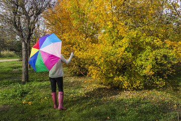 Mujer con paraguas de colores divertida en un día de otoño