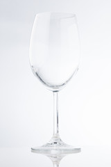 Tall empty wide wine glass with a thin stem on a white background