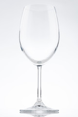 Tall empty isolated curved wine glass with a tall thin stem on a bright white background