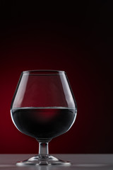 Red wine in a short-stemmed glass on a dark background