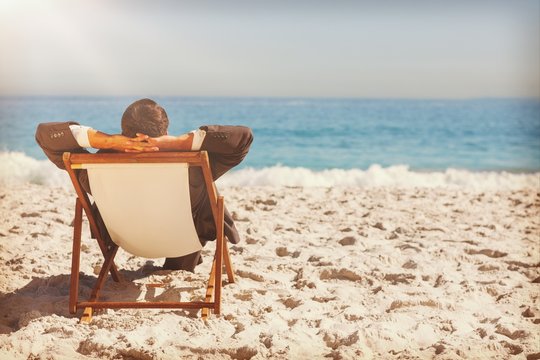 Young businessman relaxing on his sun lounger