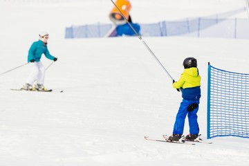 Fototapeta na wymiar Child on a ski lift going uphill.