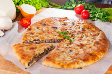 Selective Focus Traditional vegetable closed pie on the table. Composition of ingridients.